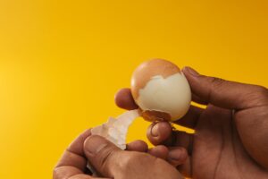 person removing egg shell